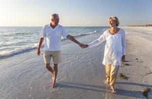 Happy Senior Couple Walking Holding Hands Tropical Beach